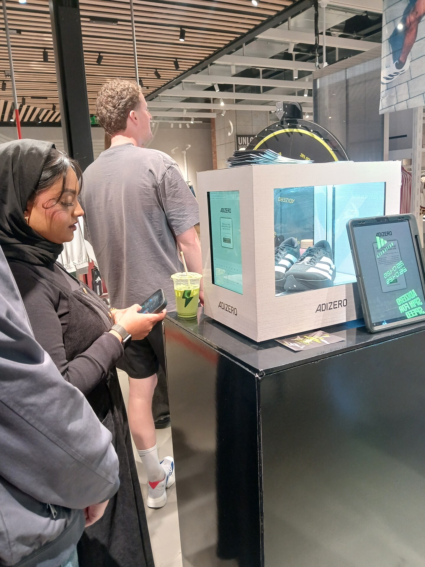 Customers engaging with the Adidas Adizero in-store display